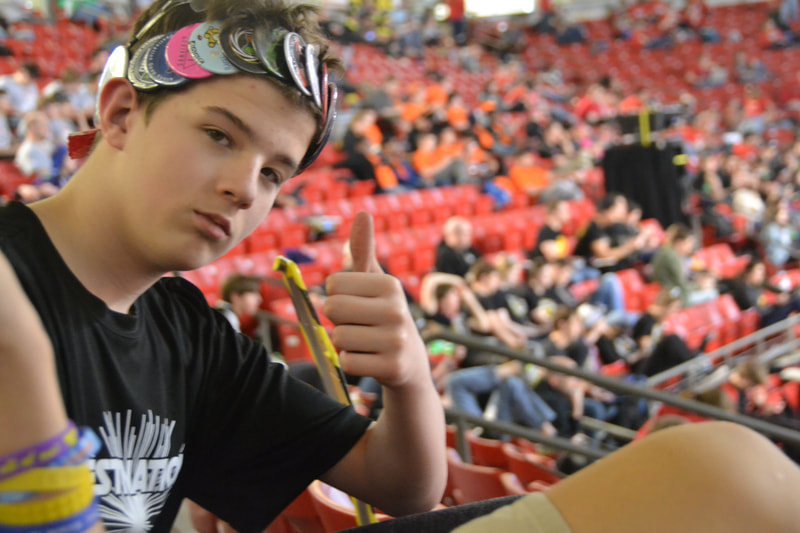 Stephen sits in the stands with pins on a headband.